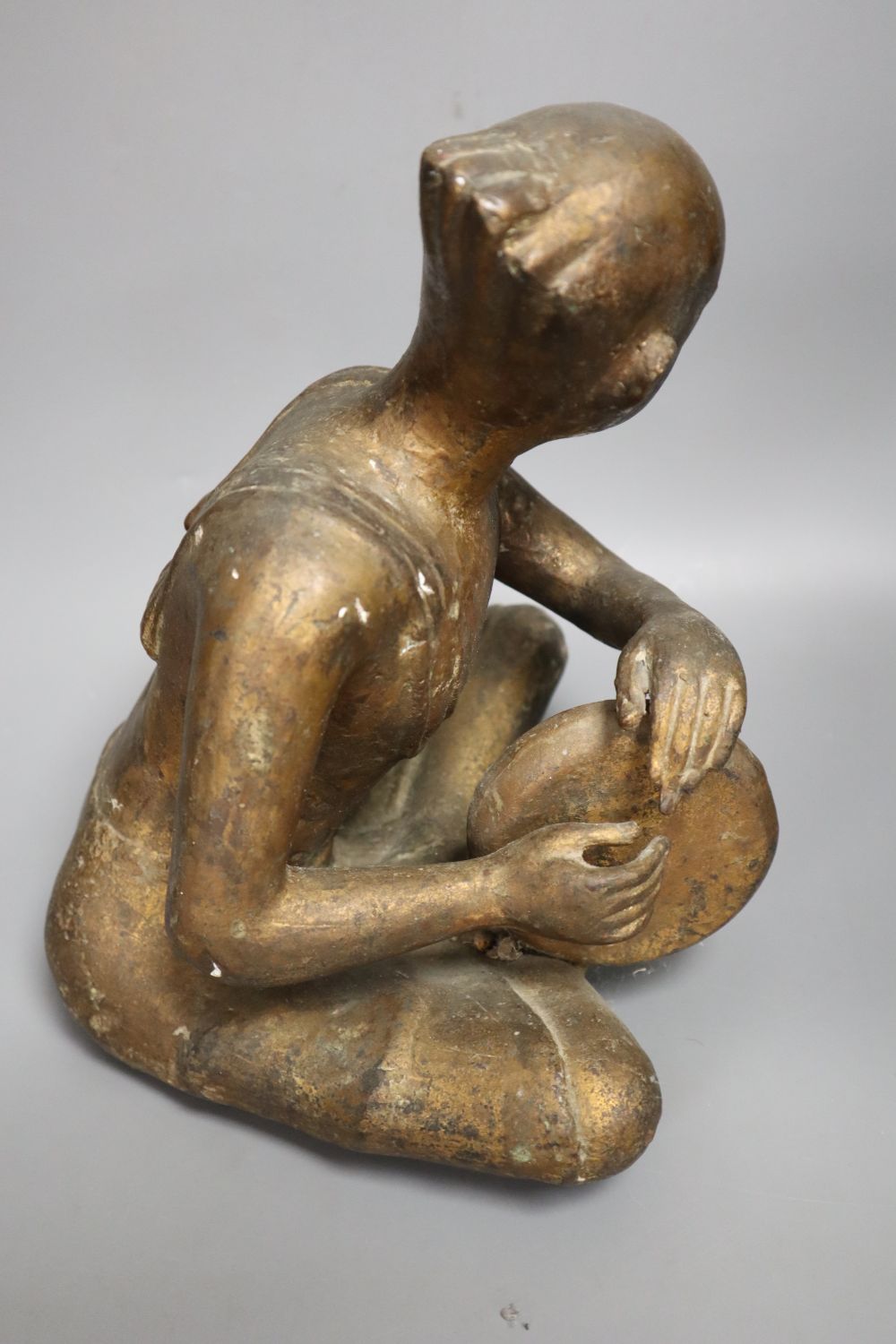 A South East Asian gilt bronze seated figure of a drummer, height 27cm